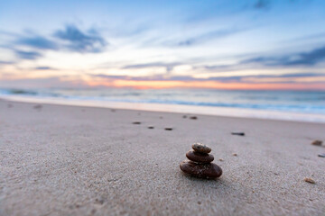 Zen stones on calm beach at sunset