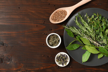 Assorted spices with fresh herbs on a wooden background. Natural food additives. Aromatic herbs and spices from garden, healthy cooking concept. Flat lay, top view