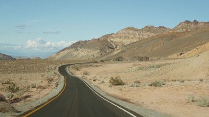 Road trip to Death Valley, Artists Palette drive, California USA. Hitchhiking auto traveling in America. Highway, colorful bare mountains and arid climate wilderness. View from car. Journey to Nevada.