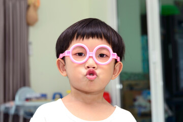 cute asian boy wearing glasses and making a funny face