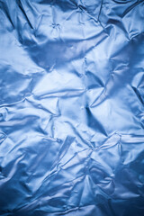 Crumpled blue aluminum foil background.