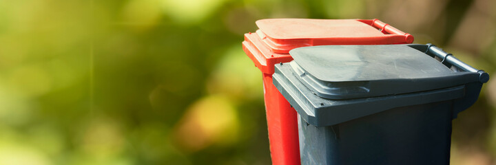 Two trash bin on green nature background. Separate and sorting garbage. Recycling and storage of...