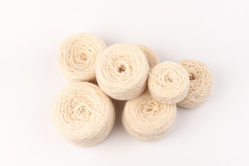 balls of light woolen thread on white background. natural wool. knitting. background