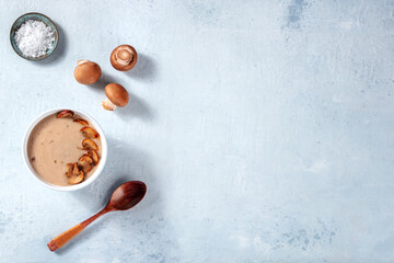 Mushroom soup, overhead flat lay shot with copy space. Portobello mushrooms, salt, a woden spoon. Organic vegan cooking