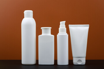 Set of beauty products for man skin care on black table against dark brown background. 