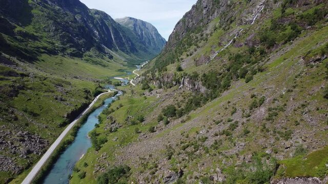 Scenic narrow and deep valley with road E39 passing through - Descending aerial with panoramic view over valley with road and river - Stardalen Valley Norway