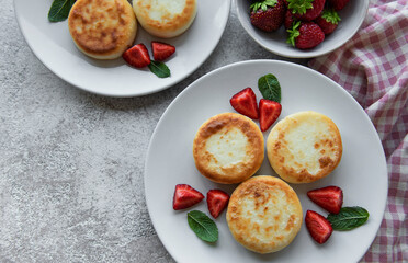 Cottage cheese pancakes, ricotta fritters on ceramic plate with  fresh strawberry.