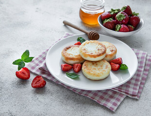Cottage cheese pancakes, ricotta fritters on ceramic plate with  fresh strawberry.