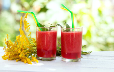Glass of watermelon smoothie on a wooden table. Selective focus