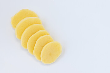 slices of peeled potatoes isolated on white background