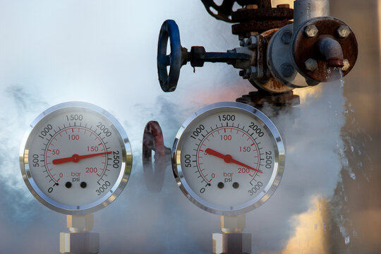 water pressure gauge meters against a leaky pipeline which comes out hot steam and hot water under pressure