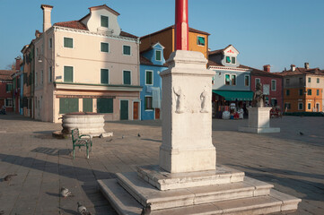 Burano, Venezia. Piazza Galuppi con plinto portabandiera e vera da pozzo