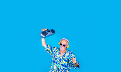 Senior man dancing clubbing with boombox and wireless headphones having fun on holiday isolated on advertising copyspace background