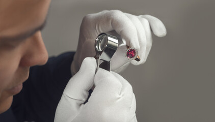 Jeweller at work. Male jeweler examining gold ruby and diamond ring. Jewelry master goldsmith...