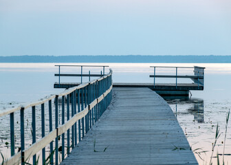 morning landscape with a wooden platform in the water, light before sunrise, silvery water