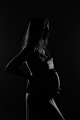 Fototapeta na wymiar silhouette of Pregnant woman on a black background
