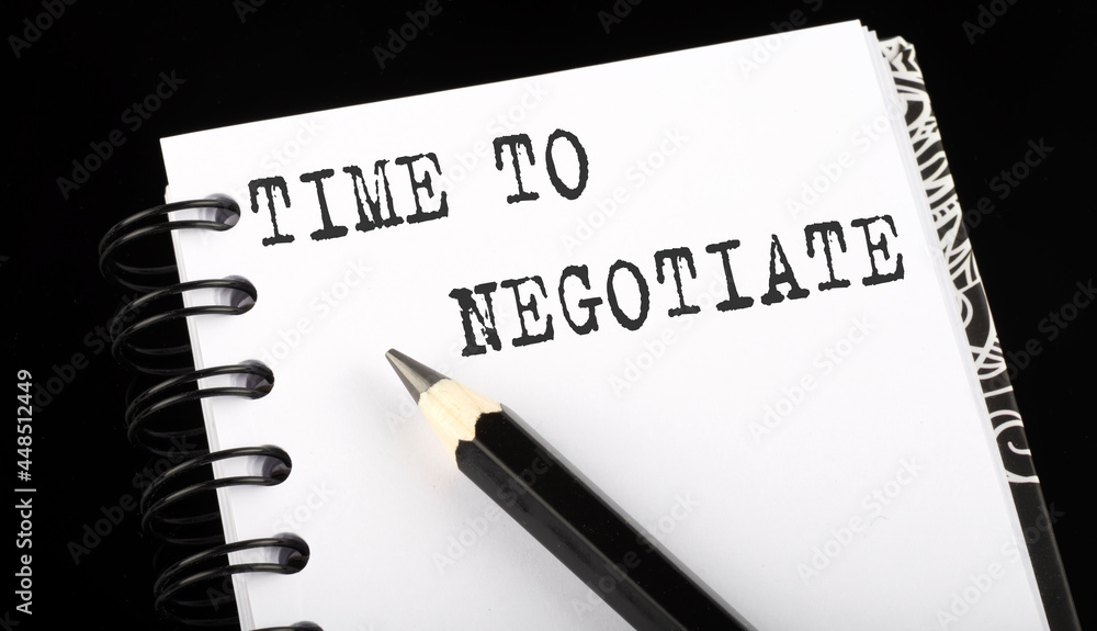 Poster time to negotiate written text in small notebook on a black background