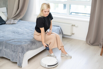 Modern life concept, woman relaxing , automatic robotic hoover clean the room while