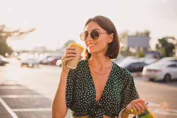 Woman at sunset with colorful shopping bags and coffee at parking lot  by shopping mall © Анастасия Каргаполов