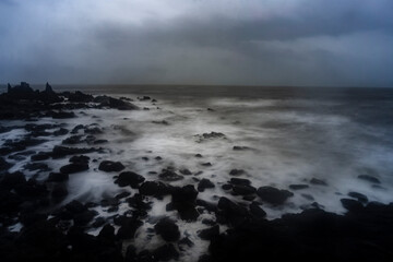 Beautiful Long exposure Image of the ocean waves hitting the big sharp rocks at the beach side of Arambol beach, Goa.