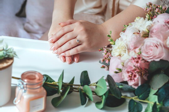 Picture of man and woman with bridal bouquet. Married couple holding hands, ceremony wedding day. Newly wed couple's hands with wedding rings.