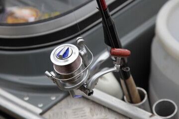 Spinning fishing rod in holder on the tube of the alloy fishing boat, fisherman equipment