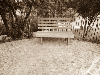 A rustic square bench in a park in southern Brazil, in vintage style photography 