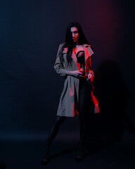 Woman in trench-coat and underwear in neon studio