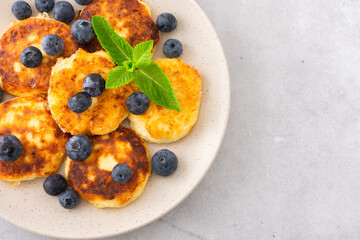 Cottage Cheese Pancake with blueberries and mint in a plate on a gray background