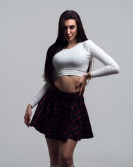 Woman in plaid skirt in the form of a schoolgirl on a white isolated background