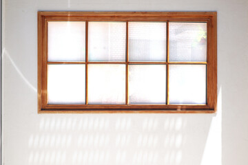 Simple wooden window frame on white background with sun light.