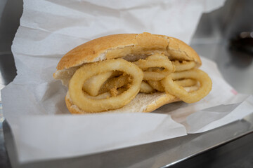 A squid sandwich on the metal bar of a bar, typical spanish food of Madrid. 