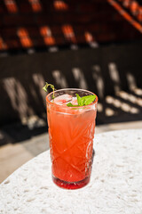 A refreshing raspberry and passion fruit lemonade in a highball glass garnished with a mint sprig...