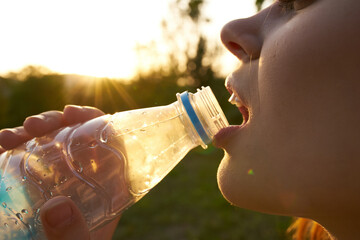 pretty woman drinking water from a bottle face close up