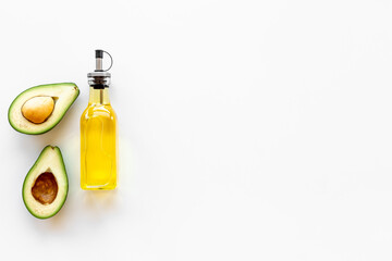 Avocado oil in glass bottle with fresh avocado