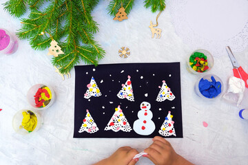 Child making a greeting card Christmas paper and  plasticine craft. Craft for children. Nice...