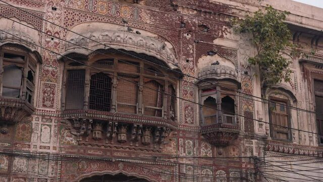 A view of The Haveli of Nau Nihal Singh located in Lahore, Pakistan, the haveli's profusely decorated with frescoes painted in the vivid Kangra style, and the other pierced with numerous windows.