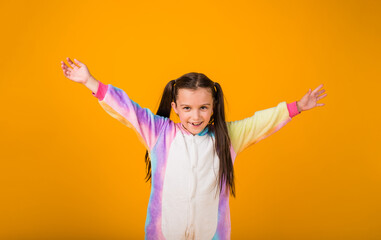 happy girl in plush pajamas enjoys on a yellow background with a place for text