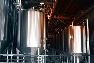 Industrial interior of modern craft brewery with chrome cylindrical metal beer tanks