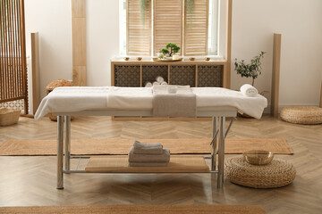 Stylish massage room interior with spa table in salon