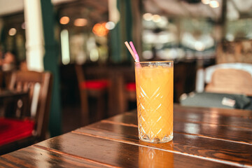 Fresh ice orange juice glass on wood table in a cafe