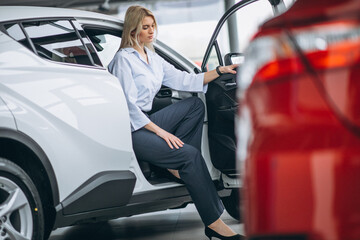 Woman sitting in a car in a car showroom