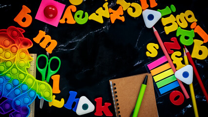Black blackboard background with coloful letters of the english alphabet. 
