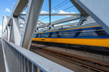 Steel railroad bridge with a passing train - 448527640