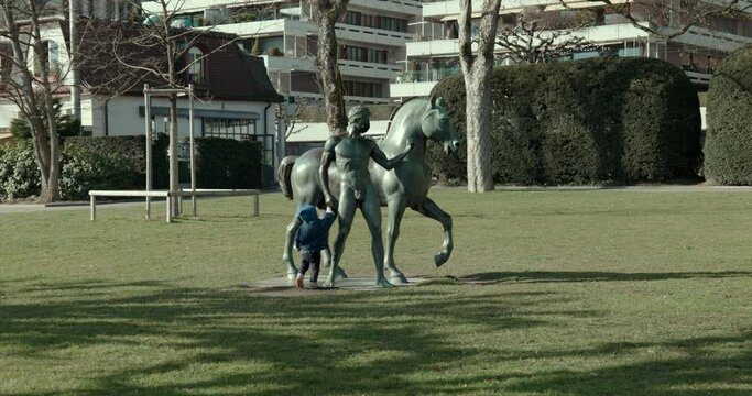 Lucerne, Switzerland - 03 03 2021: Outer day statue honoring Nobel laureate Carl Spitteler in Rössliwiese park with child