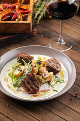 Plate of gourmet fillet mignon steaks with potatoes on a wooden background
