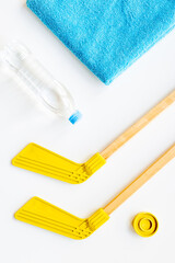 Competitive sports equipment with hockey sticks towel and bottle of water. Top view