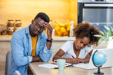 The angry father and a daughter doing homework at the desk. Father argues with his daughter about book facts. Dad is angry because his daughter don't want to do her homework