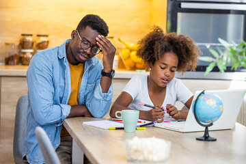 Father and daughter arguing over homework. Cute and lovely mixed race girl doing homework at home, with a help of her father. Father and daughter having trouble with homework