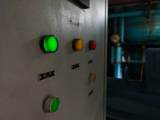 An Electrical Panel with so many buttons visible from the side lights up in red, yellow and green as the indicator lights up